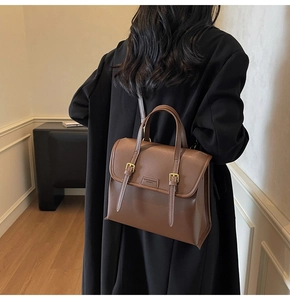 Detail of vintage brown leather backpack with gold buckles and chic vertical straps