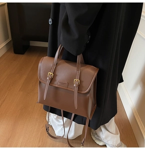 Detailed view of the vintage brown leather backpack texture and metal buckle straps