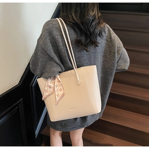 Close-up of off-white lychee leather tote bag with pink houndstooth silk scarf detail