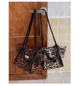 Détail de sacs cabas en toile à motif léopard en marron et beige avec bandoulières