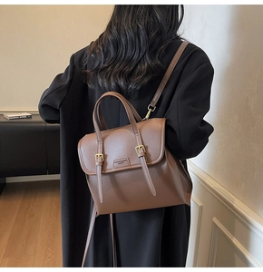 Close-up of brown vintage leather backpack with gold buckles and fashion logo lettering