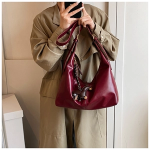 Deep red leather hobo bag with adjustable strap and vintage horse charm detail
