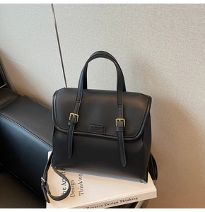 Detailed shot of a black vintage backpack with golden buckles and matte texture