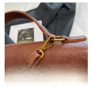 Detail of vintage brown leather backpack showing antique bronze hardware and stitching