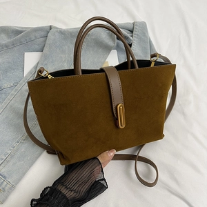 Sac fourre-tout en daim marron avec lanières en cuir et boucle dorée sur tissu blanc