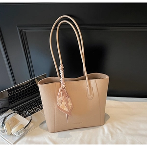 Detail of lychee pattern leather tote bag with a chic pink houndstooth silk scarf accent