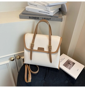 Retro contrast backpack detail with cream body, brown straps on a textured surface
