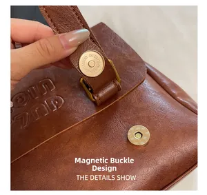Macro view of vintage brown leather bag featuring a bronze magnetic clasp and embossed detail