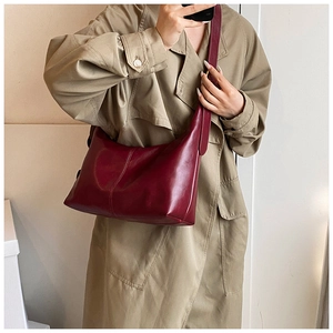 Detail of burgundy leather hobo bag with vertical stitching and wide adjustable strap