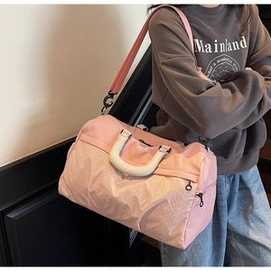 Pink large capacity travel bag with white checkered pattern and cream handles