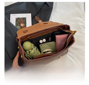 Spacious interior of vintage brown crossbody bag showing organized compartments and items