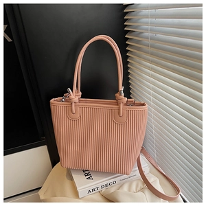 Detailed macro of pink tote bag featuring vertical pleated texture and silver hardware