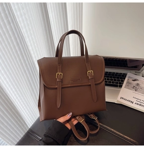 Detail of vintage brown leather backpack with buckle straps and fashion logo on flap