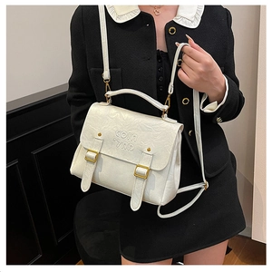 Detail of cream quilted PU leather bag with gold buckle hardware and metal logo