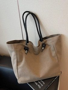 Minimalist khaki canvas tote bag with black tubular handles and knot detail for women