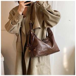 Brown half-moon crossbody bag with cute dachshund charm accessory and wide strap