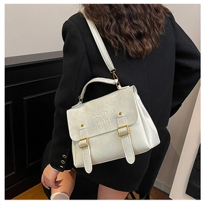 Rear view of model wearing a beige textured PU leather handbag with gold buckle