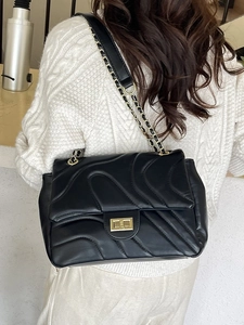 Classic black quilted crossbody bag with gold twist lock and chain strap on model