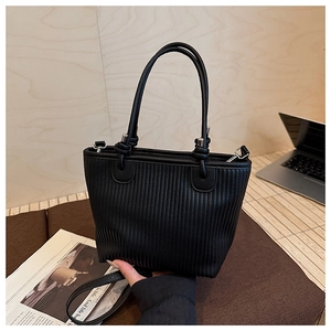 Detailed view of the black woven leather bucket bag with top handles and shoulder strap