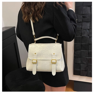 Detail of white pleated texture leather bag with gold buckle and adjustable strap