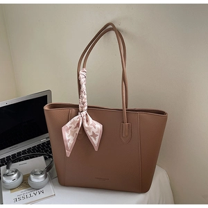 Brown tote bag with lychee texture and houndstooth silk scarf on the office desk