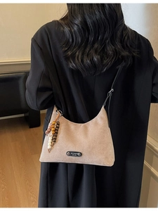 Sac hobo rétro en daim beige mat avec bandoulière noire et breloque en perles colorées