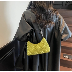Macro detail of lime green beaded shoulder bag showing textured rivet-like finish