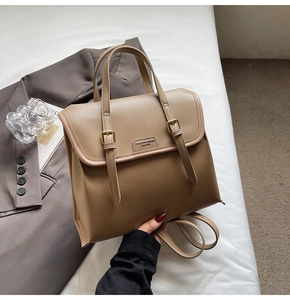 Detail of vintage khaki leather backpack with gold buckle straps and fashion logo