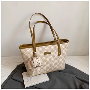 Detail of checkered tote bag with brown leather trim and cute white plush rabbit charm