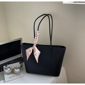 Close-up of black lychee grain leather tote bag featuring a pink houndstooth silk scarf detail