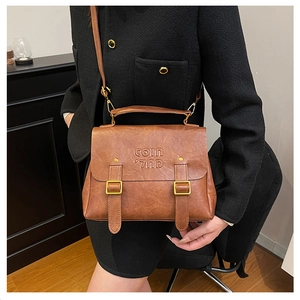 Detail of vintage brown leather backpack with buckle straps and embossed logo textures
