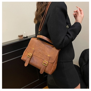 Detailed view of vintage brown leather backpack with adjustable straps worn by model