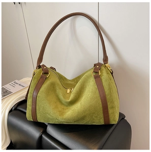 Dettaglio della borsa tote in pelle scamosciata verde con cinturini in pelle marrone e zip dorata
