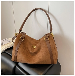Dettaglio della borsa tote in pelle scamosciata marrone con manici in pelle e zip d'oro