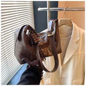 Detailed view of brown retro leather underarm bag with chocolate and horse charms