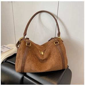 Dettaglio ravvicinato della borsa tote in pelle scamosciata marrone con rivetti dorati