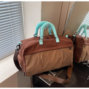 Detail view of large brown and blue travel bag with durable checkered grid texture