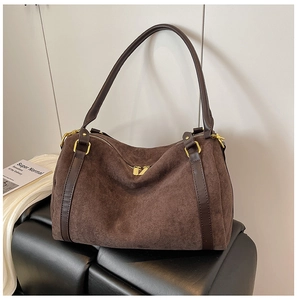 Dettaglio borsa boston in pelle scamosciata con manici in pelle e cerniere dorate