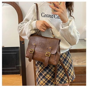 Detail of vintage brown textured leather backpack with gold buckles and COIN 7ND engraving