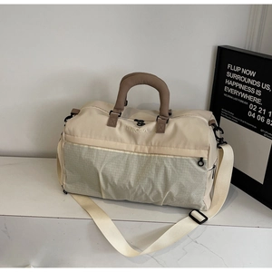 Detail of travel bag showing waterproof fabric, brown handles and detachable shoulder strap