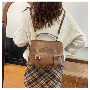 Detail of vintage brown leather backpack showing flap closure and metal buckle straps
