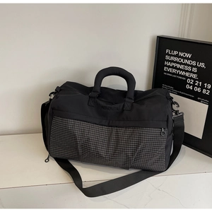 Detail showing the gray checkered pattern and NINGJIA logo on the black travel bag