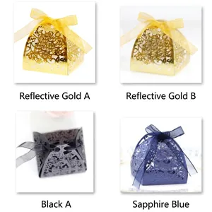 Laser cut favor boxes with ribbons in gold, black, and sapphire blue for wedding candy