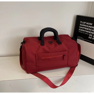 Close-up of red large-capacity travel bag with durable nylon and adjustable strap