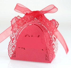 Détails de dentelle découpée au laser sur boîte cadeau rouge avec un ruban en organza