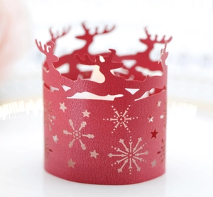 Detailed laser-cut red paper candle wrap featuring Christmas deer and snowflake patterns