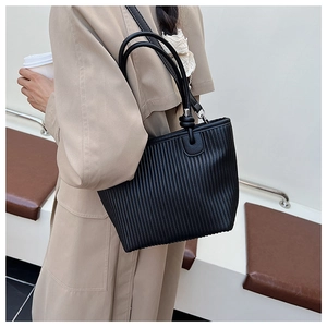 Detail shot of the black pleated tote bag showing the textured synthetic leather material