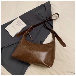 Detail of vintage brown leather hobo bag with antique gold hardware and stitching