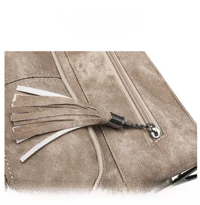 Detail of khaki twill bag showing silver zipper pull with long decorative tassels