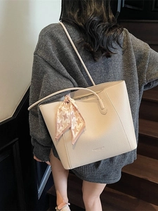 Beige faux leather tote bag with pink houndstooth scarf on a shoulder model